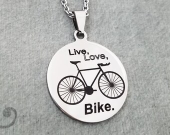 May include: A silver necklace with a round pendant featuring a black silhouette of a bicycle and the text "Live, Love, Bike."