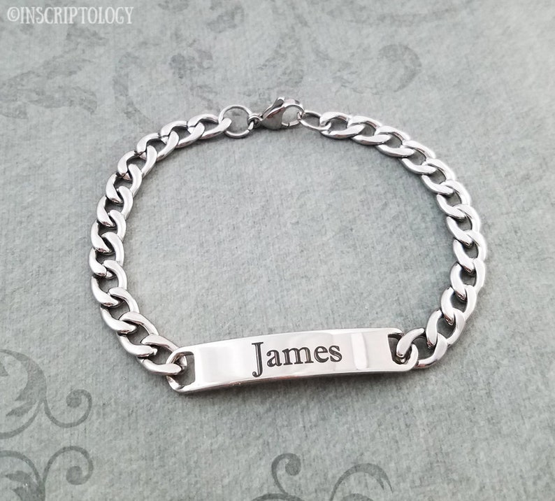 May include: A silver chain bracelet with a rectangular tag that says "James" engraved on it.