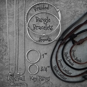 May include: A variety of silver chains, key rings, and leather cords. The chains include a link ball chain and a smooth chain. The key rings are 1 inch and 3/4 inch in diameter. The leather cords are brown suede, black suede, brown leather, and black leather.