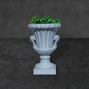 Peut inclure: Un pot de fleurs en pierre grise avec une base carrée et deux poignées sur les côtés. Le pot est rempli de plantes vertes feuillues.