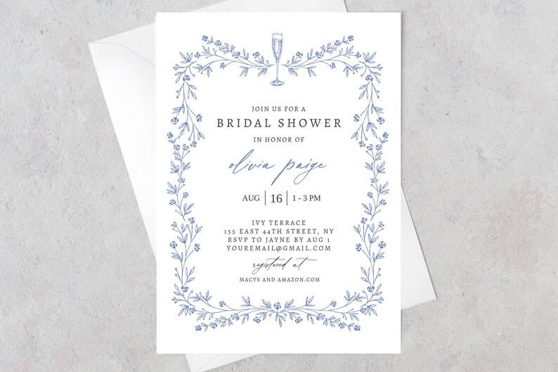 May include: A white bridal shower invitation with a blue floral border. The text reads "Join us for a Bridal Shower in honor of Olivia Paige Aug | 16 | 1-3PM Ivy Terrace 155 East 44th Street, NY RSVP to Jayne by Aug 1 youremail@gmail.com Registered at Macys and Amazon.com"
