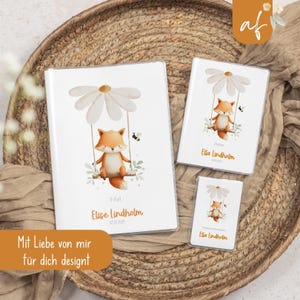 Könnte beinhalten: Ein Set aus weißen Notizbüchern und einer kleinen Karte mit einer Aquarellillustration eines Fuchses auf einer Schaukel unter einer Gänseblume. Der Fuchs ist orange und weiß, mit einer Biene. Die Notizbücher tragen den Namen "Elise Lindholm" und das Datum 02.02.2024.
