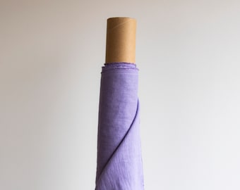 May include: A roll of lavender-colored fabric wrapped around a cardboard tube.
