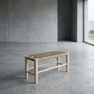 Può includere: Una panca rettangolare con una struttura in legno chiaro, quattro gambe cilindriche e barre di supporto orizzontali. La seduta è realizzata con una corda in fibra naturale intrecciata e testurizzata color beige, con un motivo a griglia.