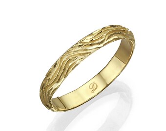 May include: A gold wedding band with a textured wave design. The band is inscribed with the letter "D".