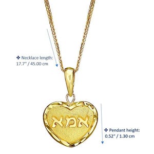 Puede incluir: Un collar con colgante en forma de coraz&oacute;n de oro con la palabra hebrea 'אמא' en el centro. La longitud del collar es de 45,00 cm y la altura del colgante es de 1,30 cm. La pieza tiene un acabado texturizado y un borde pulido.