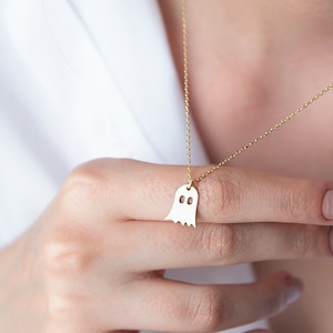 A gold chain necklace with a ghost-shaped pendant