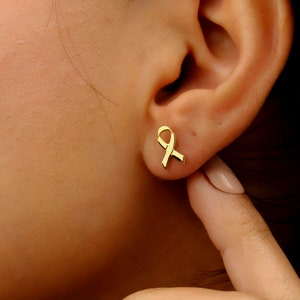 A pair of gold ribbon earrings