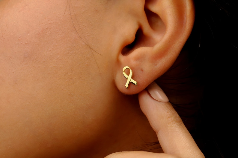 A pair of gold ribbon earrings
