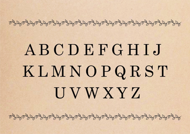 A black and white alphabet on a brown background with a vine border. The alphabet is in uppercase letters and is centered on the page. The letters are spaced evenly apart. The vine border is made up of small leaves and is located at the top and bottom of the page.