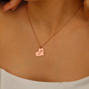 A rose gold heart-shaped pendant necklace with the inscription 'I am strong, like the sea'.