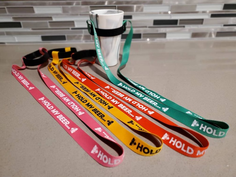 K&ouml;nnte beinhalten: Ein Satz bunter Lanyards mit dem Aufdruck "Hold My Beer..." Die Lanyards sind aus einem weichen, strapazierf&auml;higen Material gefertigt und perfekt, um Ihr Getr&auml;nk zu halten.