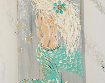 Mermaid painting an old barn board.
