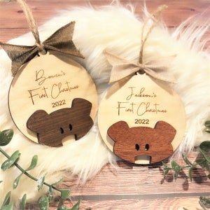 May include: Two wooden Christmas ornaments with a bear design. Each ornament has a burlap bow and twine for hanging. One ornament says "Bowen's First Christmas 2022" and the other says "Jackson's First Christmas 2022".