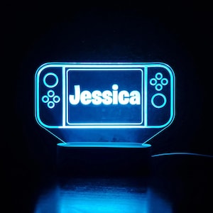 May include: A blue light-up nightlight shaped like a video game console with the name "Jessica" on the screen.
