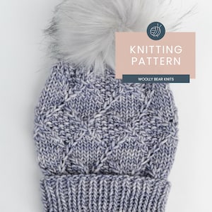 Pode incluir: Um padrão de tricô para um gorro azul e branco com um pompom. O padrão é intitulado "Woolly Bear Knits" e é para um gorro de tricô.