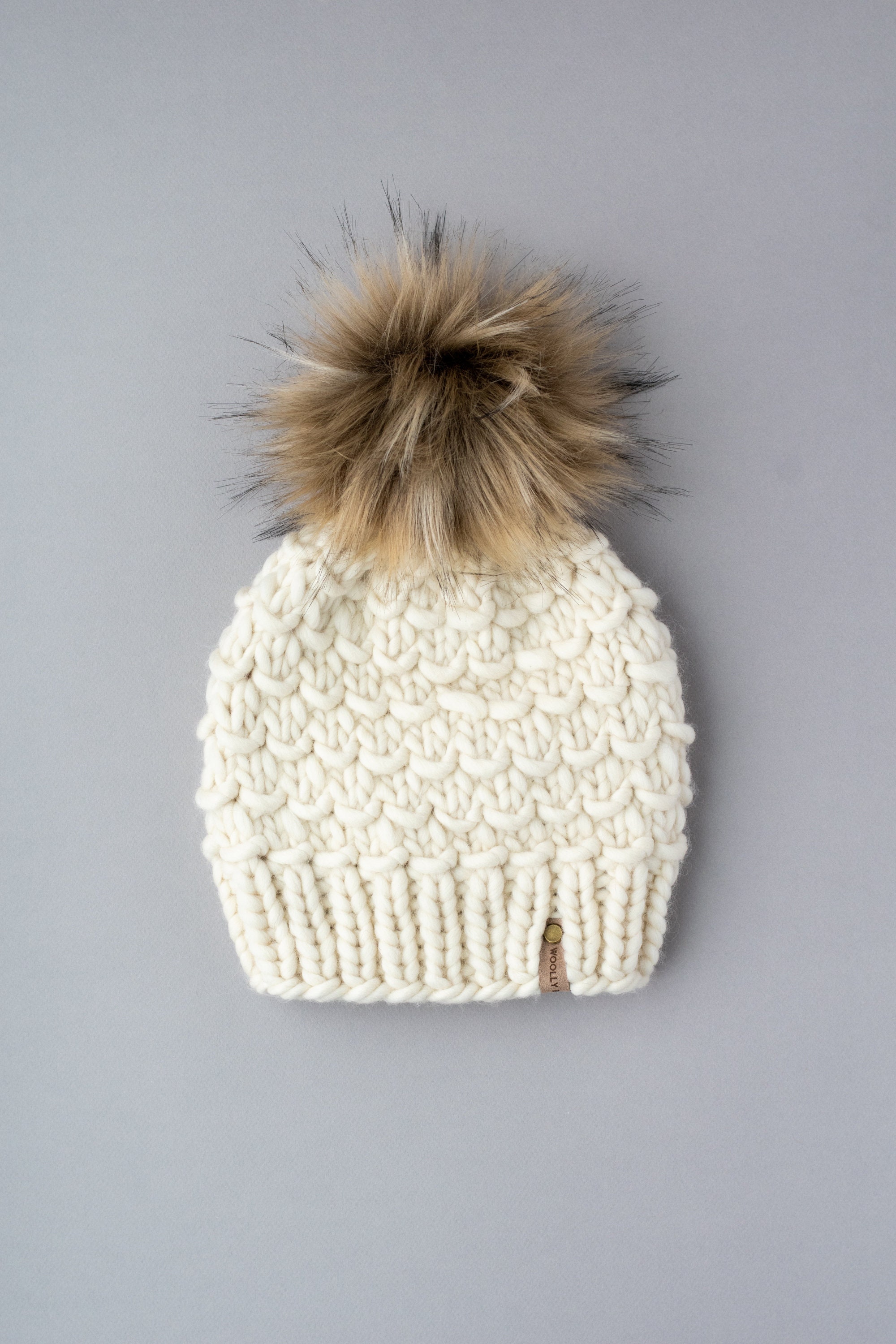 cream hat with fur pom pom