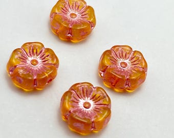 Four Czech glass hibiscus flower beads in translucent orange with pink wash detail on a plain white background.