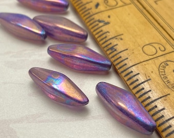 Six purple mother of pearl effect rhombus beads displayed next to a wooden ruler for scale.