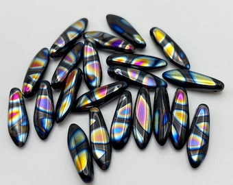 Twenty Czech glass dagger beads in jet black with iridescent peacock zebra stripe patterns on a plain background.