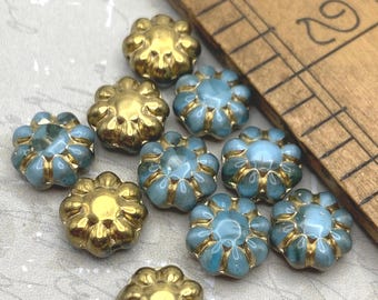 Twelve Czech glass cactus flower beads in turquoise blue with gold wash, shown with a ruler for scale.
