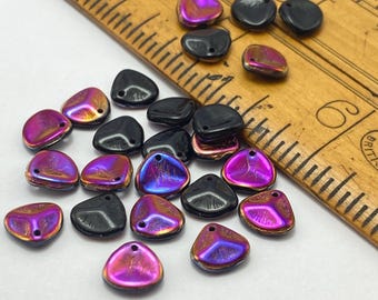 Twenty-five black cerise AB Czech glass rose petal beads arranged next to a wooden ruler for scale.