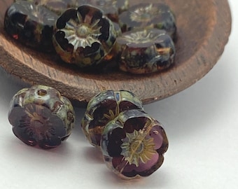 Czech hibiscus flower beads in deep purple plum with picasso finish, shown both loose and in a ceramic dish for scale.