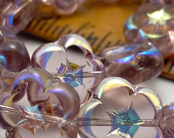 Czech glass flower beads in pink with iridescent AB finish, strung on wire with a ruler visible in the background for scale.
