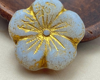 Single pale lilac Czech hibiscus flower bead with etched gold detail on petals, shown resting on a wooden surface.