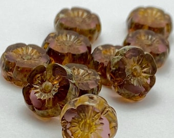 Ten rosewood pink Czech glass hibiscus flower beads with bronze wash metallic details on a white background.