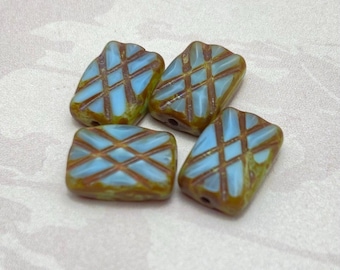 Four turquoise blue Czech table cut rectangle beads with etched brown crosshatch pattern on a plain background.