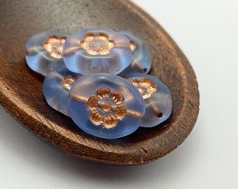 Six matte lilac-blue Czech oval flower beads with copper wash detail nestled in a wooden dish.