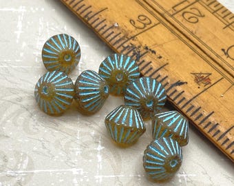 Eight matte topaz tribal bicone beads with turquoise wash displayed next to a wooden ruler for scale.