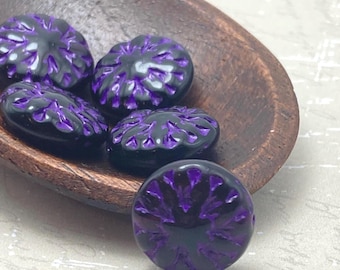 Five Czech glass dahlia flower beads in black with purple wash, shown next to a wooden ruler for scale.