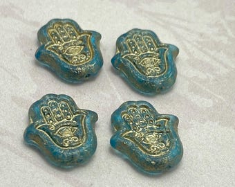 Four Czech glass hamsa hand beads in matte blue-green with gold wash, shown on a plain white background.