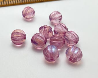 Ten rose pink Czech glass melon beads with AB finish and grooved surfaces, displayed next to a wooden ruler for scale.