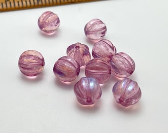 Ten rose pink Czech glass melon beads with AB finish and grooved surfaces, displayed next to a wooden ruler for scale.