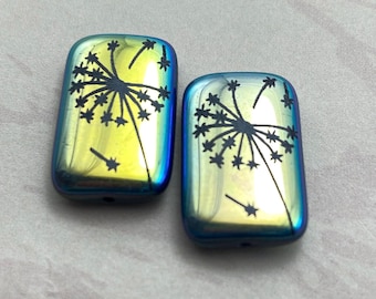 Two Czech glass rectangle beads with laser etched dandelion design on a neutral background, featuring yellow and cream.