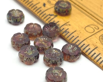 Czech hibiscus flower beads in deep purple plum with picasso finish, shown both loose and in a ceramic dish for scale.