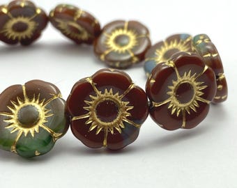 Brown and teal Czech glass flower beads with gold wash in sunburst pattern, arranged on plain white background.