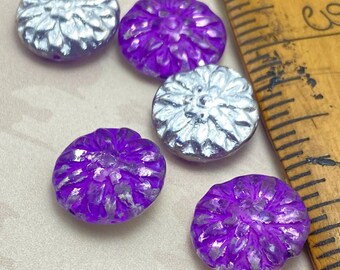Five Czech glass dahlia flower beads, three purple and two silver, beside a wooden ruler for scale.