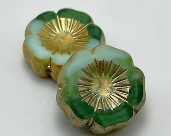 Two Czech glass flower beads in green and turquoise with gold wash centres, shown on a plain white background.