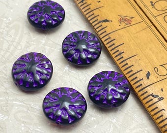 Five Czech glass dahlia flower beads in black with purple wash, shown next to a wooden ruler for scale.