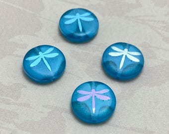 Four blue opal Czech glass coin beads with etched dragonfly designs on a plain background.