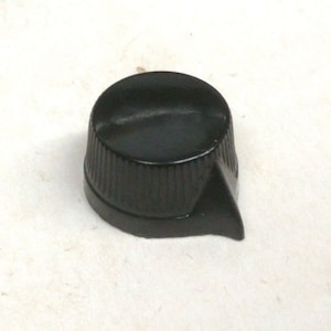 May include: Black plastic knob with a pointed edge and a ribbed design.