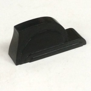 May include: A black, geometric, abstract sculpture made of a hard, smooth material. The sculpture has a rounded, curved shape and a flat base.