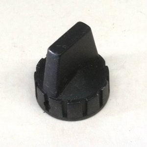 May include: Black plastic knob with a flat, rectangular top. The knob has a ridged base.