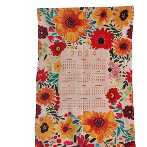 May include: A kitchen towel with a floral design and a calendar for the year 2024 printed on it. The flowers are in shades of red, orange, yellow, and green.