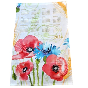 May include: A white tea towel with a 2024 calendar printed in gold lettering. The calendar is surrounded by watercolor illustrations of red poppies and blue cornflowers.