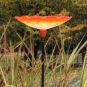 Orange Birdbath seated on top of rebar.